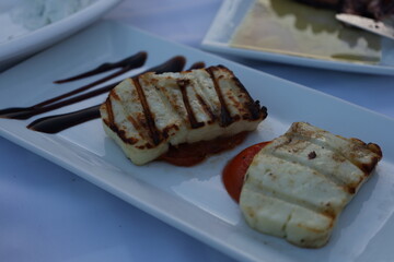 Grilled Haloumi cheese on a plate in a Greek restaurant during summer
