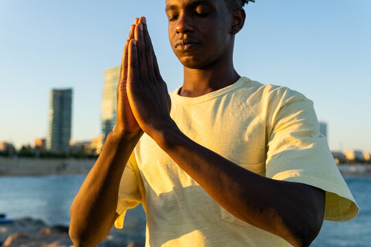 Black man with eyes closed on street
