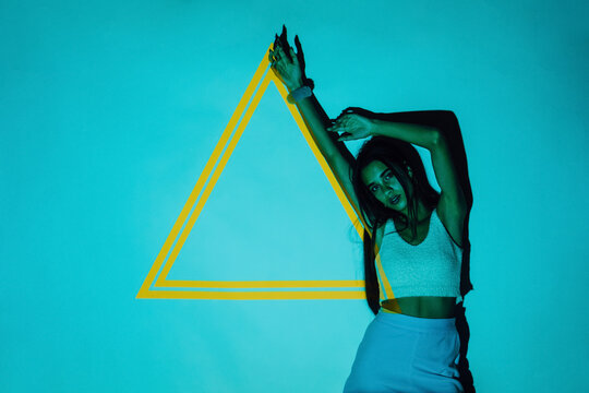 Cool Hispanic model against triangle on blue background