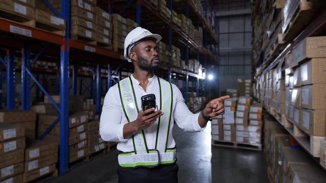 Business concept of 4k Resolution. African man checking goods in warehouse.