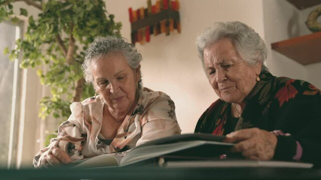 Aged women examining photos together