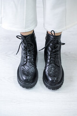 Crop of trendy autumn woman s fashion outfit: purple velour quilted bag, blue midi skirt, black chunky ankle boots. Copy, empty space for text