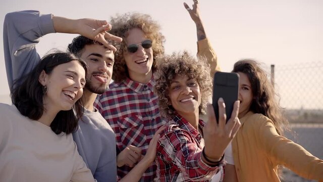 Group of multiracial happy friends taking selfie and having fun together. Slow motion.