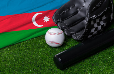 Baseball bat, glove and ball near Azerbaijan flag on green grass background