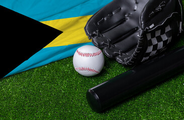 Baseball bat, glove and ball near Bahamas flag on green grass background