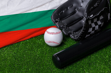 Baseball bat, glove and ball near Bulgaria flag on green grass background