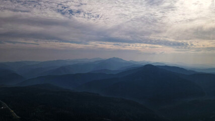 Obraz na płótnie Canvas Mountain range, aerial, cliffs, sun rays, clouds, morning