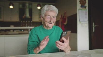 Senior female waving into mobile phone to say goodbye and end her video call