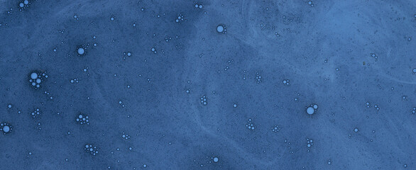 Abstract background, web banner of tiny air bubbles suspended in a thick blue liquid. Flat lay top view