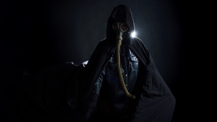 A gloomy man in dark clothes, a black hood on his head, a gas mask protects his face. A character...