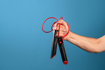 Actively move and be healthy, sports and a healthy lifestyle, concept. A man's hand holds a rope in his fist, blue background