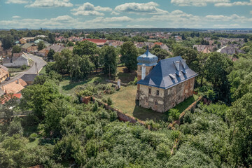 Aerial view of medieval fortified castle Erdody manor house in Janoshaza, Vas county Hungary with restored onion shape roof and blue sky, surrounded by a dry moat