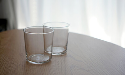 左側にコピースペースがある木製のテーブルに置かれたグラスセットの写真