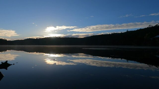 白駒池の紅葉と鏡のような湖面に鏡のように映る日の出