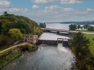 aerial view of historic dam on the river with bridge and highway with lake in background during autumn  water spilling over dam  wheelhouse  © Southport Images