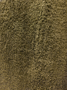 Greenish yellow cloth fibre towel texture, darker patches towards the centre, olive green with depth