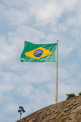 brazil flag outdoors with a beautiful blue sky.