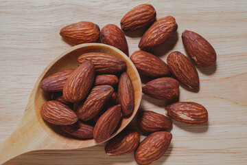 Almond close-up in a wooden spoon on the table, top view. Healthy food concept.