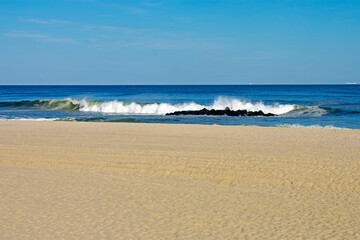 Atlantic ocean waves crashing into sandy beach at Spring Lake, New Jersey, on a sunny afternoon -02