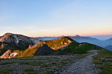 夜明けを迎える白馬岳　朝日を受けて輝く槍ヶ岳、剱岳の絶景