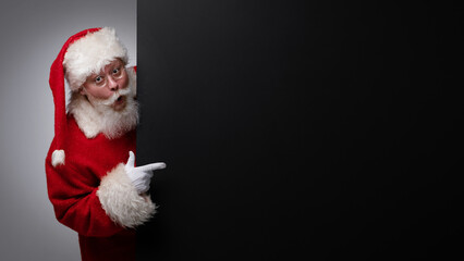 Santa Claus pointing black billboard