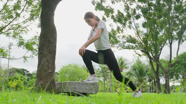 Asian young sport woman stretch body warm up before exercise in park. 