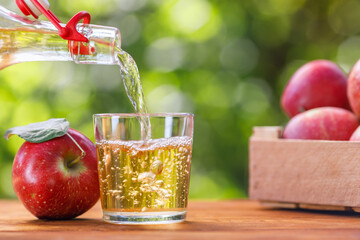 apple cider or juice pouring in glass from bottle