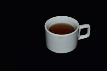 black coffee in white ceramic cup on black background