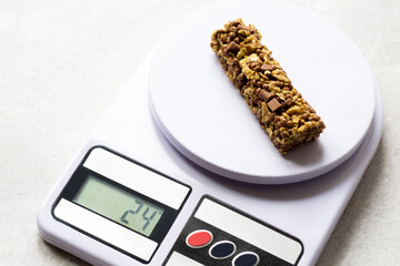 A healthy cereal bar on the kitchen scales.