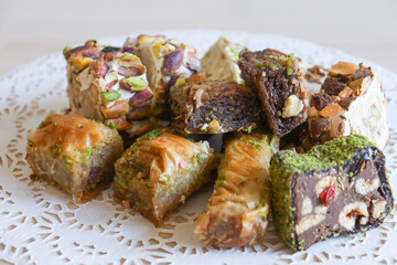 traditional Turkish sweets, baklava, lies on a beautiful napkin on the table. Treats, delicacies, nuts, nougat. Turkish sweets