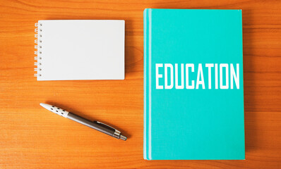 Education - the word is written on the diary, near a pen and a notebook for writing, the concept of education on a wooden table.