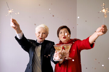 Two beautiful stylish mature senior women celebrating new year. Fun, party, style, celebration...