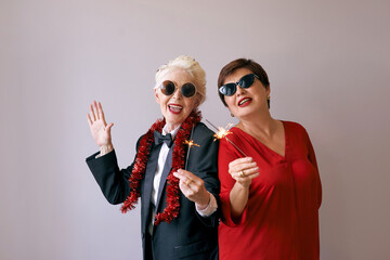 Two beautiful stylish mature senior women celebrating new year. Fun, party, style, celebration concept 