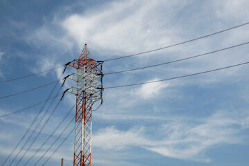 Electrical pole with transmission line against blue sky background