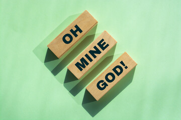 Oh Mine God printed on a wooden blocks on green background. Oh Mine God exclamation shocking concept.