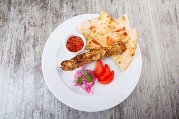 focacia with kebabs and hot red sauce