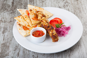 focacia with kebabs and hot red sauce
