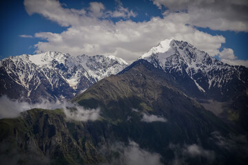 Fototapeta na wymiar Mountain Ridge with Snow-Capped Peaks at North Ossetia. Caucasus Range