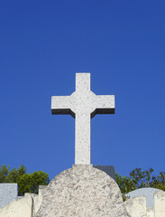 White cross in the Saint Pierre cemetery in Marseille with blue sky.