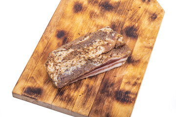 wooden board in retro style. a piece of bacon is cut into pieces on it. on a white background. close-up.