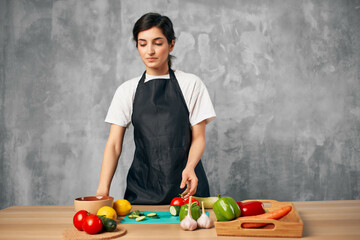 woman on the kitchen cutting vegetables cutting board