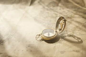 Retro style antique golden compass (sundial) and old nautical chart close-up. Vintage still life....