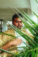 portrait of dark skinned man surrounded by leaves