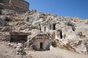 Lycian rock tombs over blue sky at location Tlos Ancient City, Turkey
