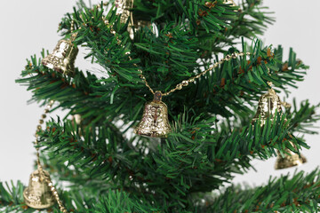 Fototapeta na wymiar Golden bell on an artificial Christmas tree.