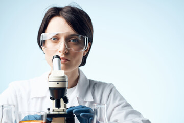 laboratory assistant sitting at the table microscope research biotechnology light background