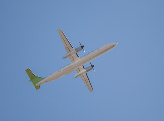 White plane flies in the sky. Bottom view. Takeoff and landing. Arrival and departure. Passenger plane isolated on blue background. Passenger airplane. Travel by air transport. Copy space. Flying.