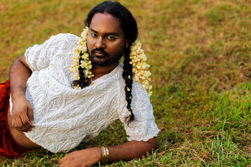portrait of dark skinned Indian non-binary individual with traditional female attire in park