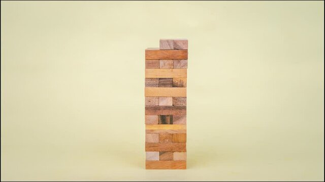 Stop motion animation Game with wooden blocks on yellow background.
