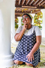 dark skinned Indian non-binary individual smiling in park